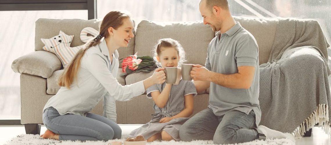 A joyful family enjoying quality time and coffee in a bright living room, symbolizing love and togetherness.